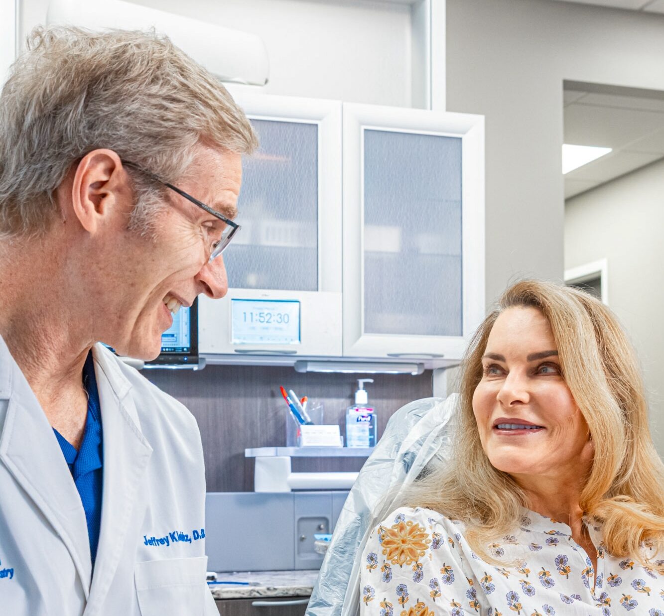 Dentist smiles with patient discussing tooth whiteners in Charlotte.