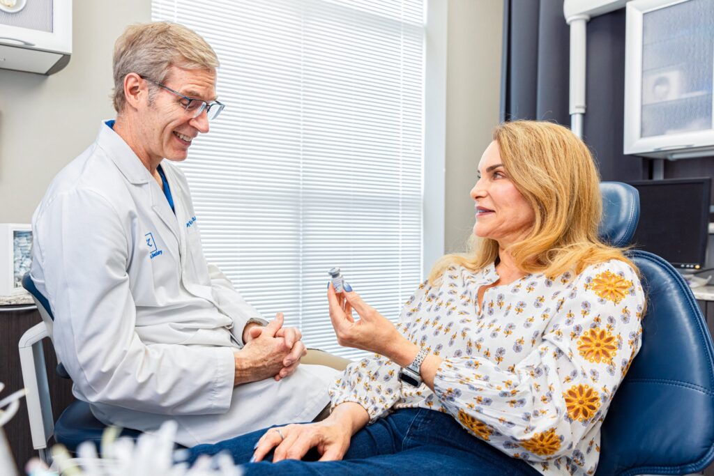 A patient holds up a vial of filler for lip augmentation in Charlotte.